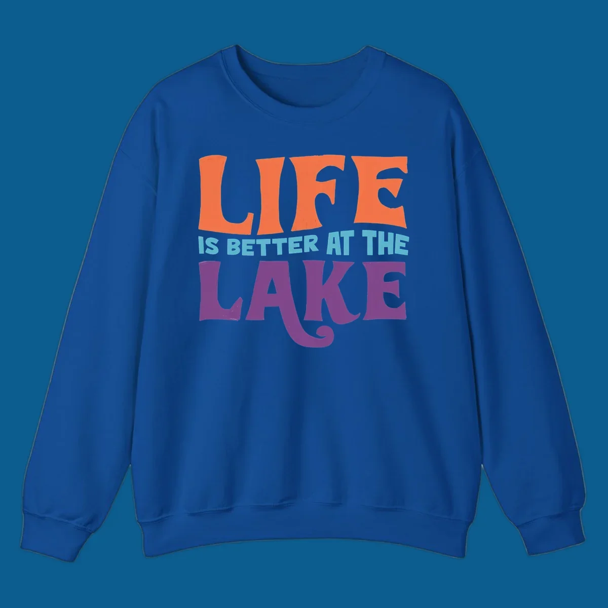Retro typography design stating "LIFE IS BETTER AT THE LAKE" in orange, teal, and purple.