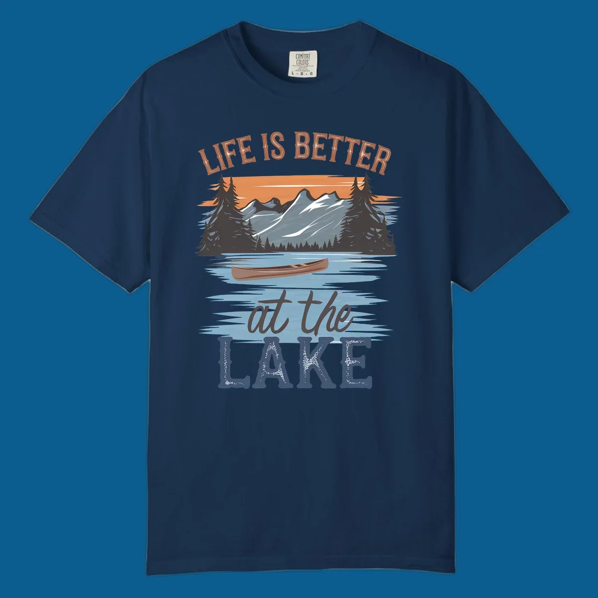 Life is better at the lake scenic design with mountains, canoe, and text.