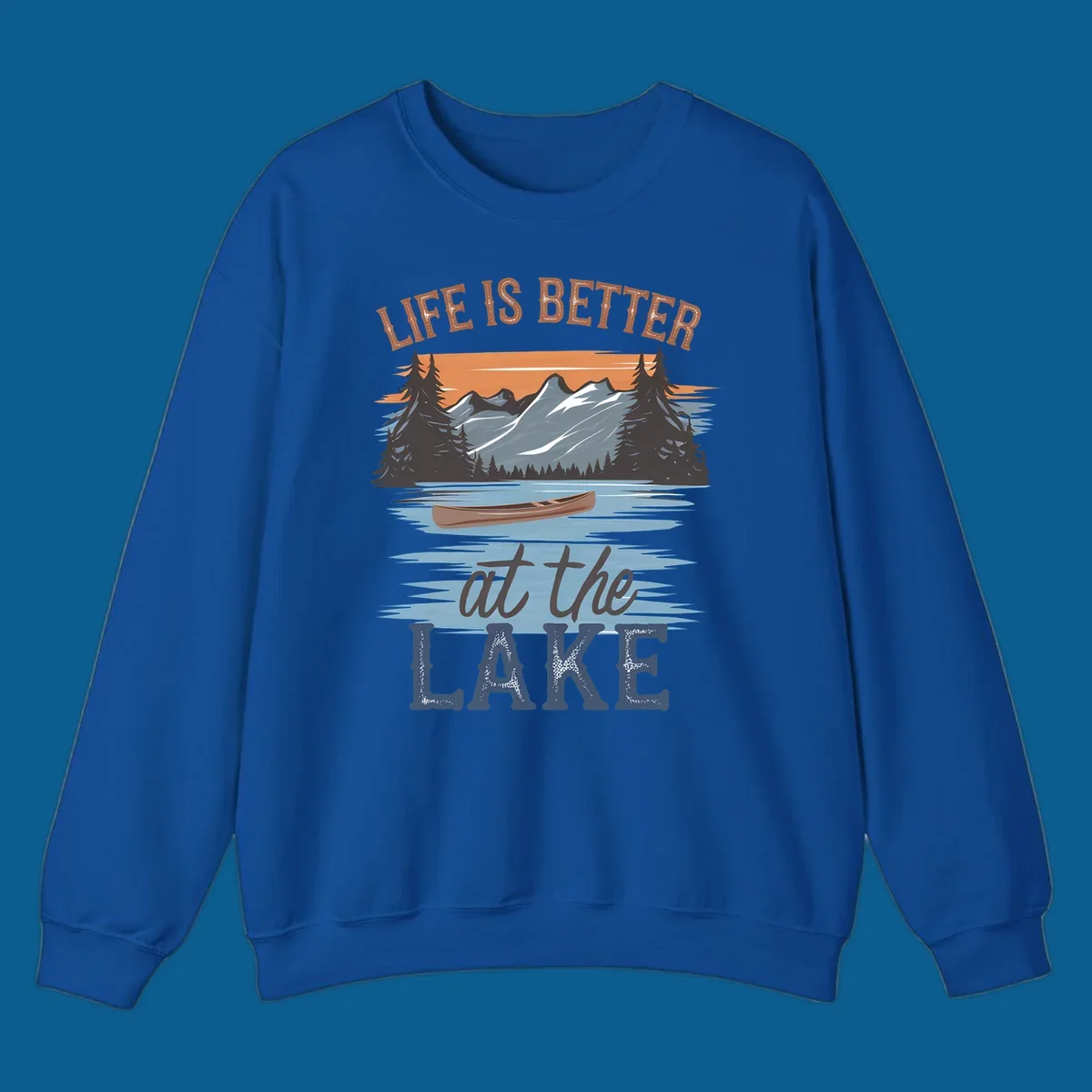 Life is better at the lake scenic design with mountains, canoe, and text.