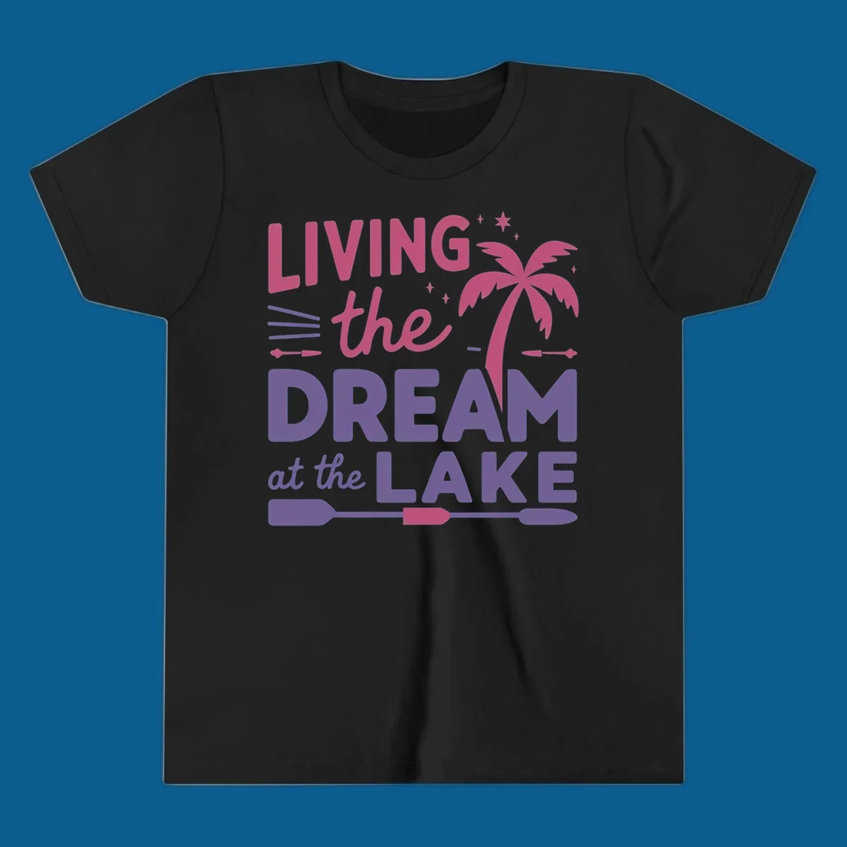 Living the dream at the lake text with palm tree and oars graphic