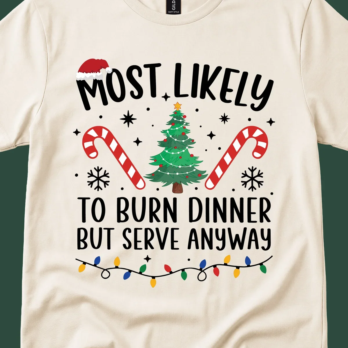 Most likely to burn dinner but serve anyway funny Christmas text with Santa hat, Christmas tree, and candy canes.