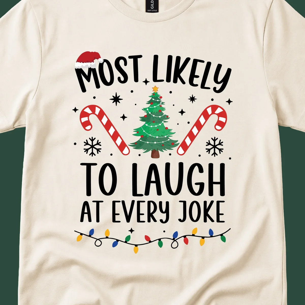 Most Likely To Laugh At Every Joke Christmas text with Santa hat, tree, candy canes, and lights.