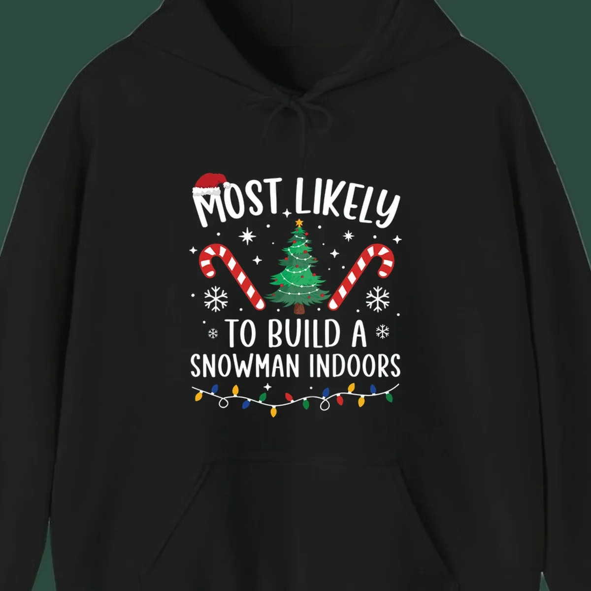 Most Likely To Build A Snowman Indoors text with Christmas graphics, including a tree and candy canes.