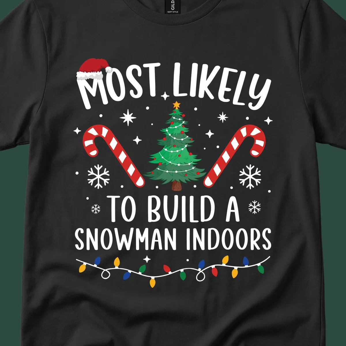 Most Likely To Build A Snowman Indoors text with Christmas graphics, including a tree and candy canes.