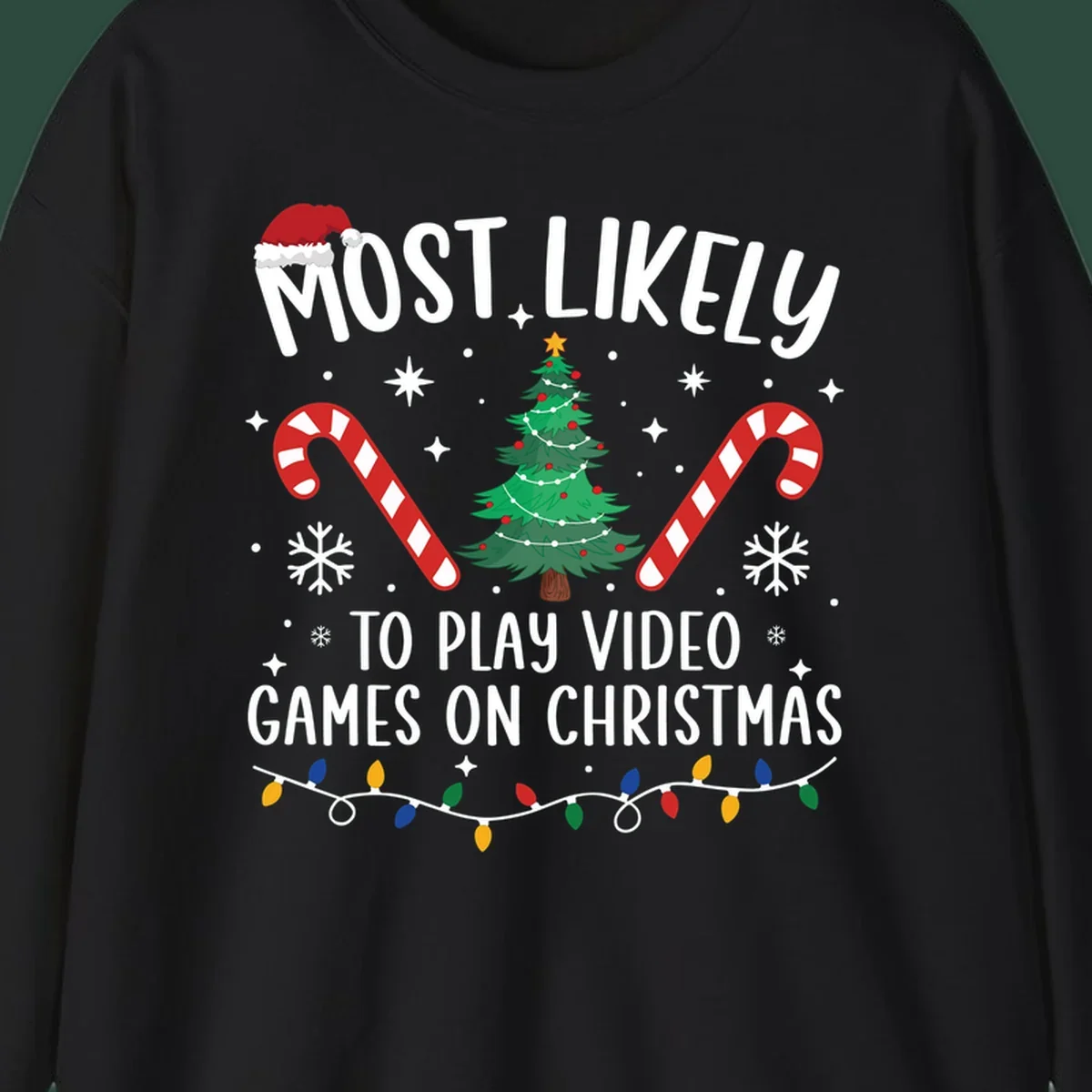 Most Likely To Play Video Games On Christmas design with text, Christmas tree, candy canes, and lights.