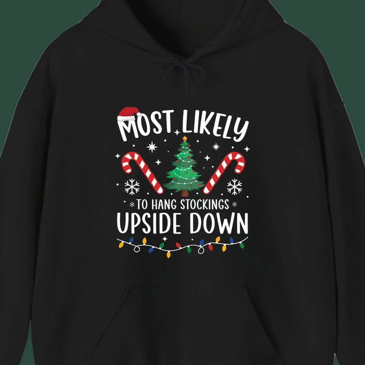 Most Likely To Hang Stockings Upside Down Christmas graphic with tree, candy canes, and Santa hat.