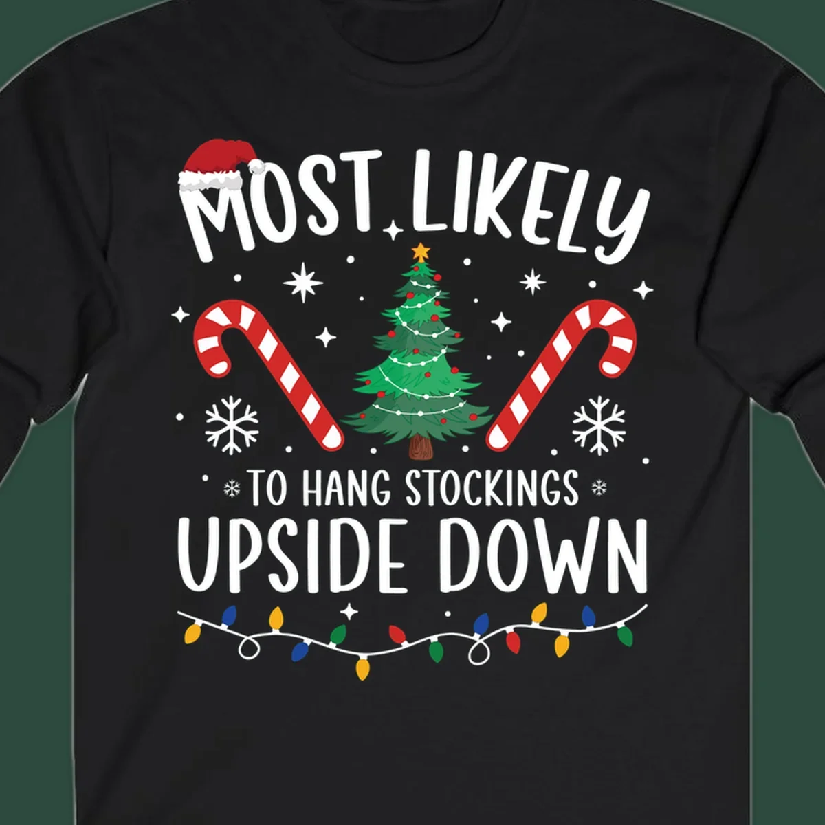 Most Likely To Hang Stockings Upside Down Christmas graphic with tree, candy canes, and Santa hat.