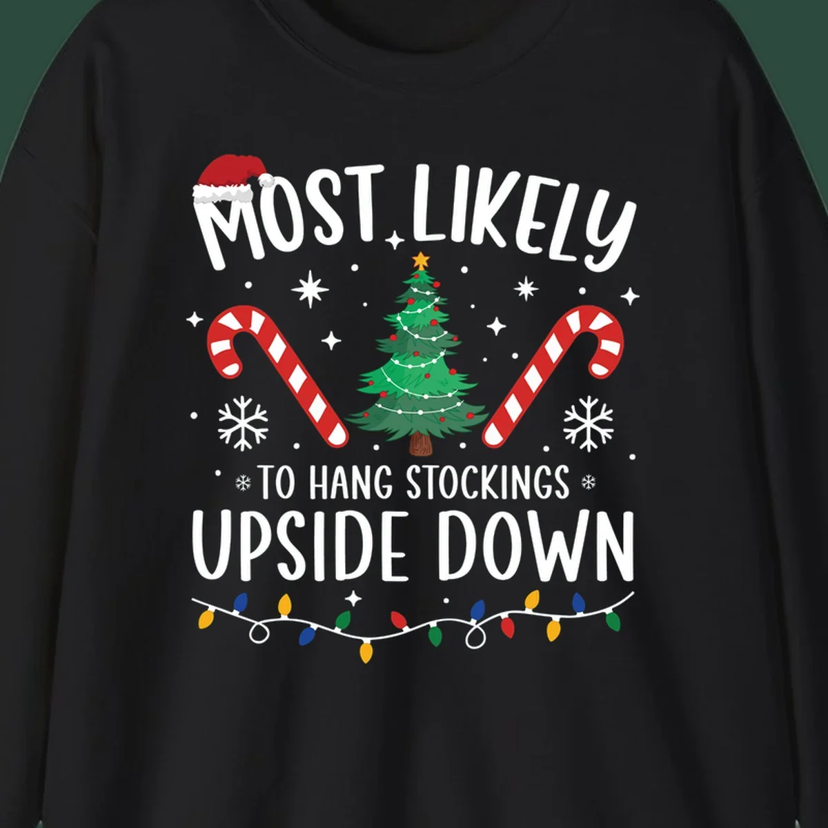 Most Likely To Hang Stockings Upside Down Christmas graphic with tree, candy canes, and Santa hat.