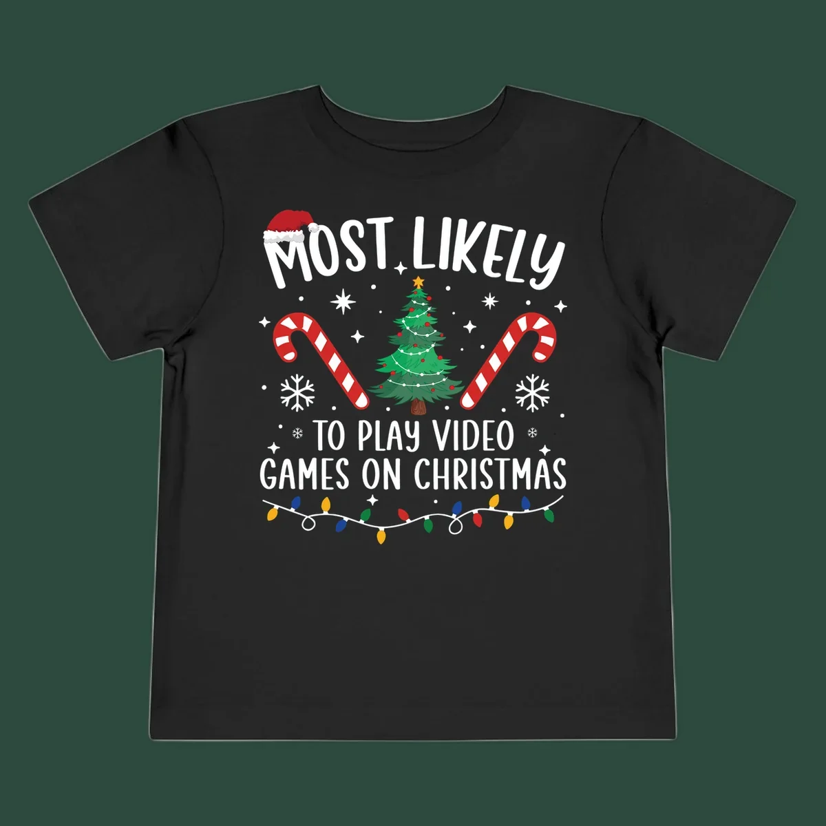 Most Likely To Play Video Games On Christmas design with text, Christmas tree, candy canes, and lights.