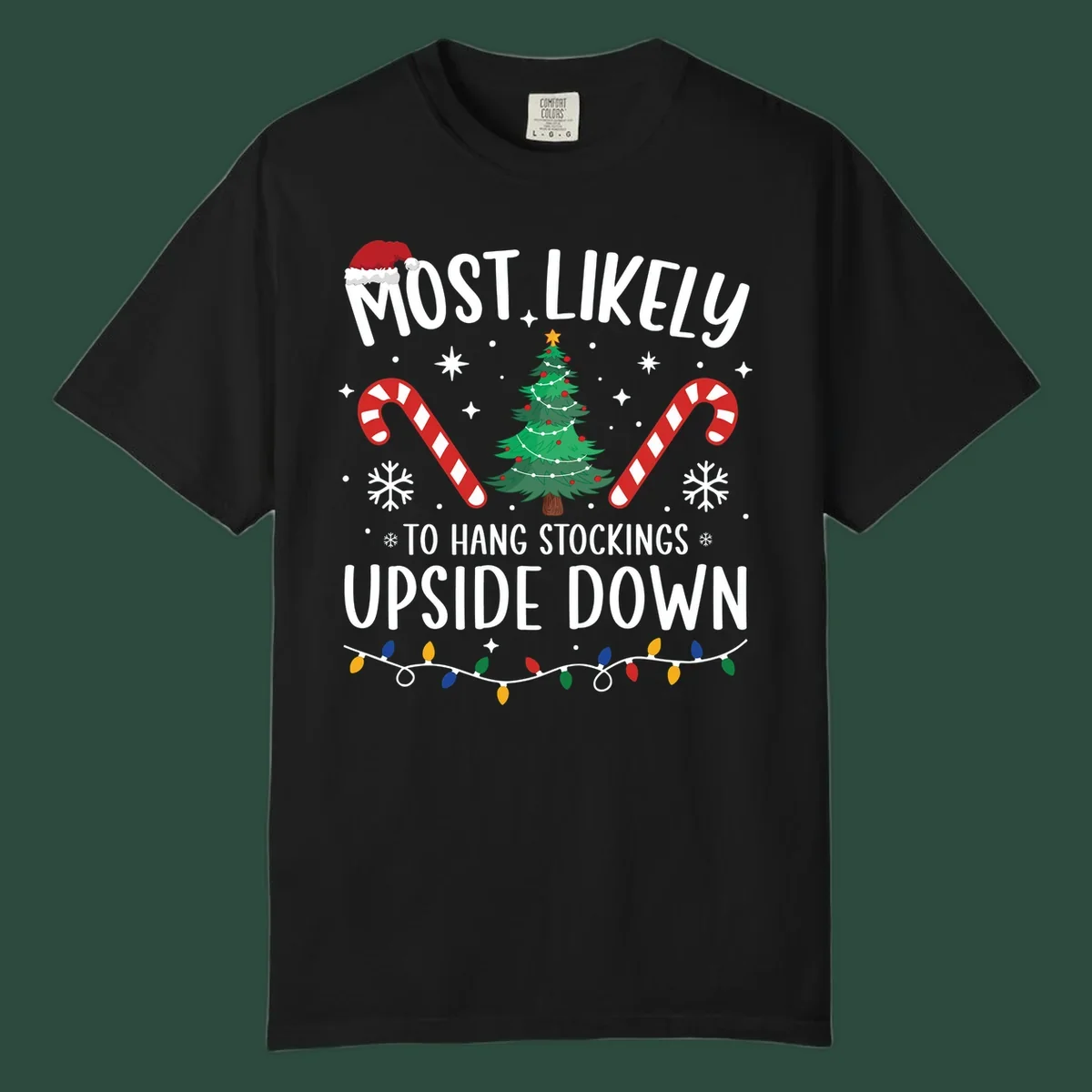 Most Likely To Hang Stockings Upside Down Christmas graphic with tree, candy canes, and Santa hat.