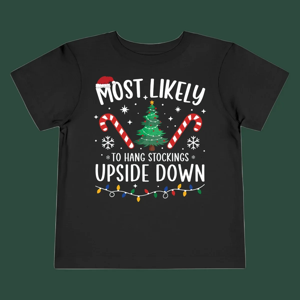 Most Likely To Hang Stockings Upside Down Christmas graphic with tree, candy canes, and Santa hat.