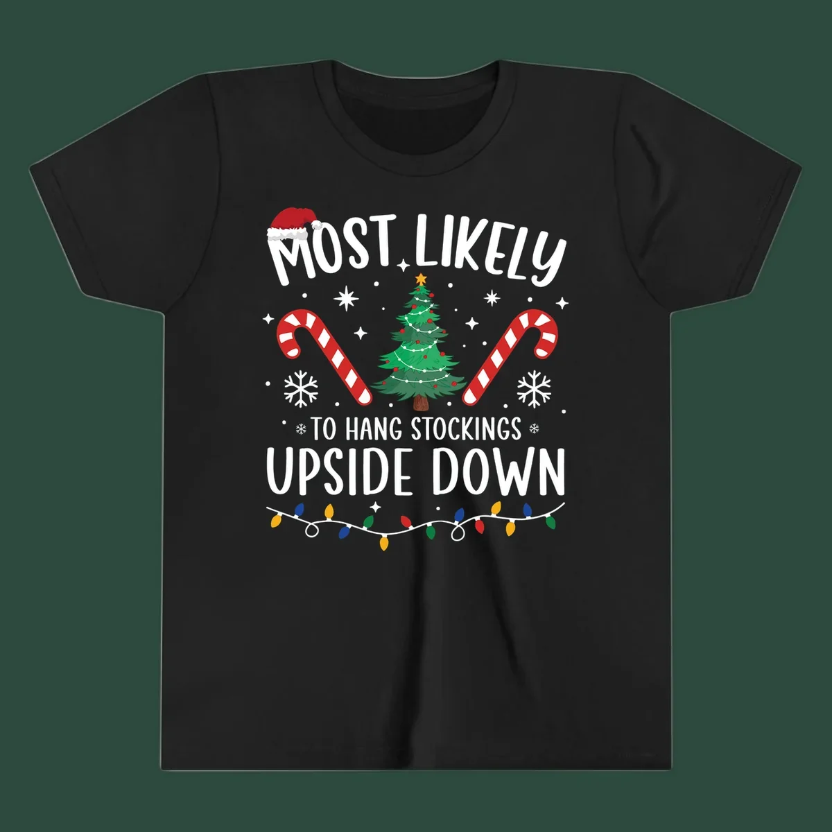 Most Likely To Hang Stockings Upside Down Christmas graphic with tree, candy canes, and Santa hat.
