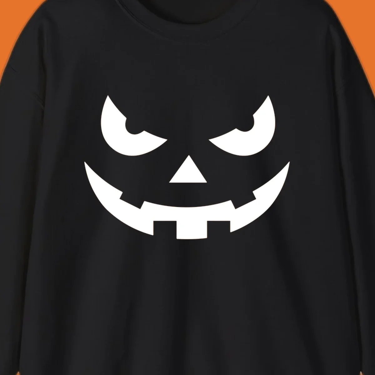 Spooky pumpkin face graphic with sharp eyes and a jagged grin.