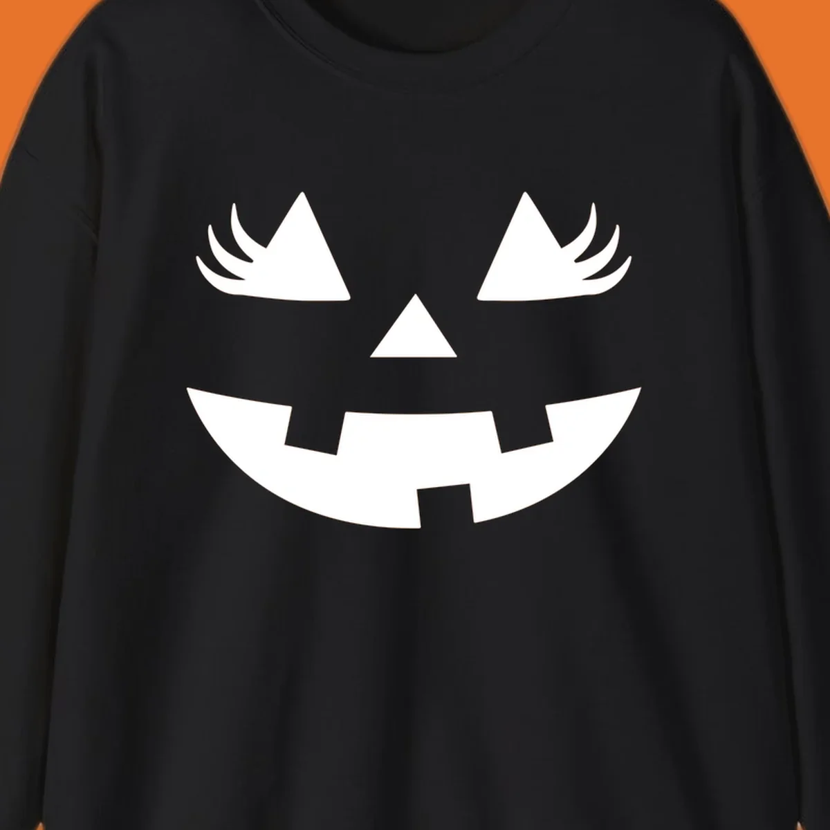 Jack o' lantern face with triangle eyes, nose, and jagged smile, featuring eyelashes.