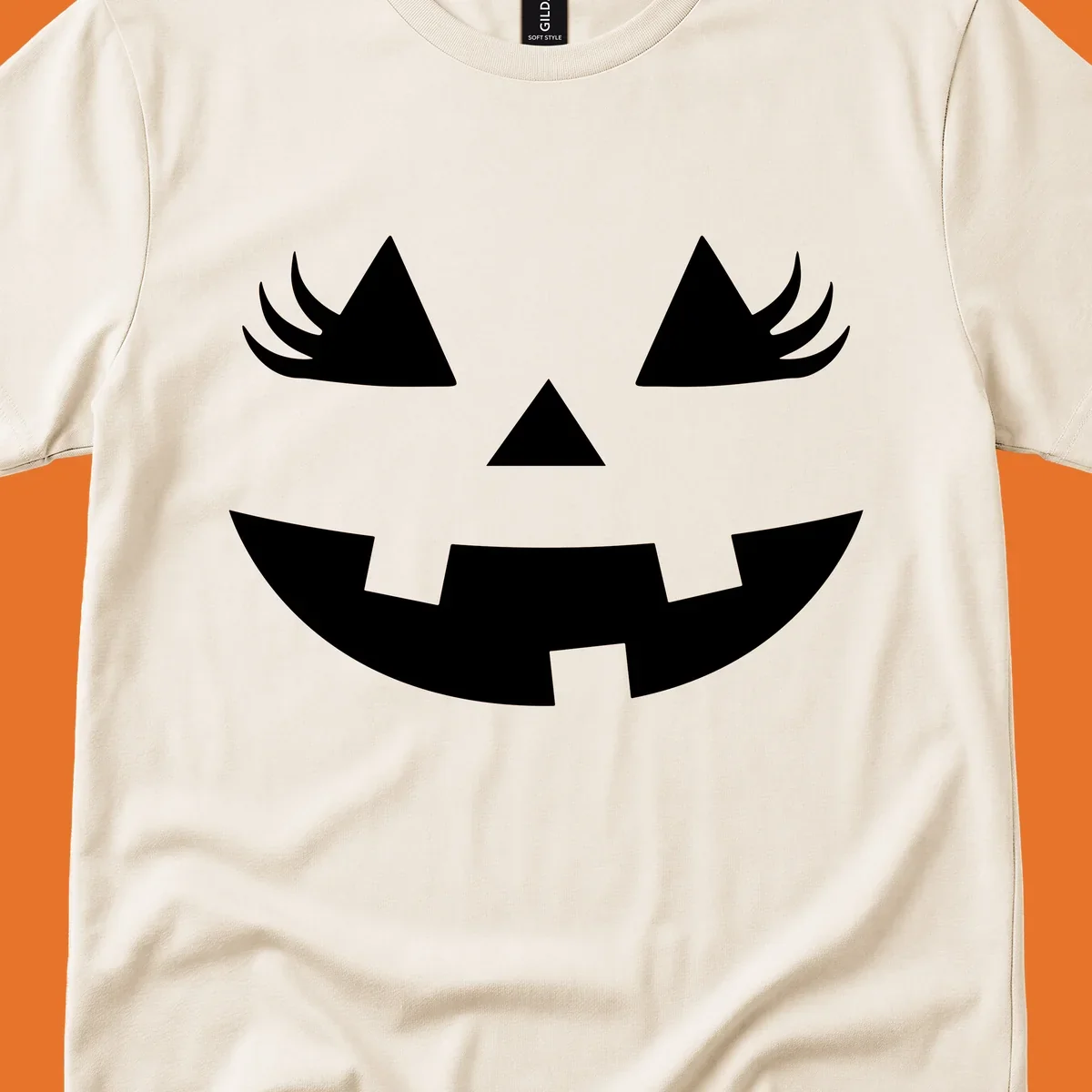 Jack o' lantern face with triangle eyes, nose, and jagged smile, featuring eyelashes.