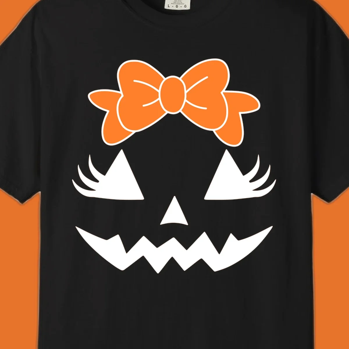 Cute pumpkin face graphic with orange bow, triangle eyes, nose, and jagged smile.