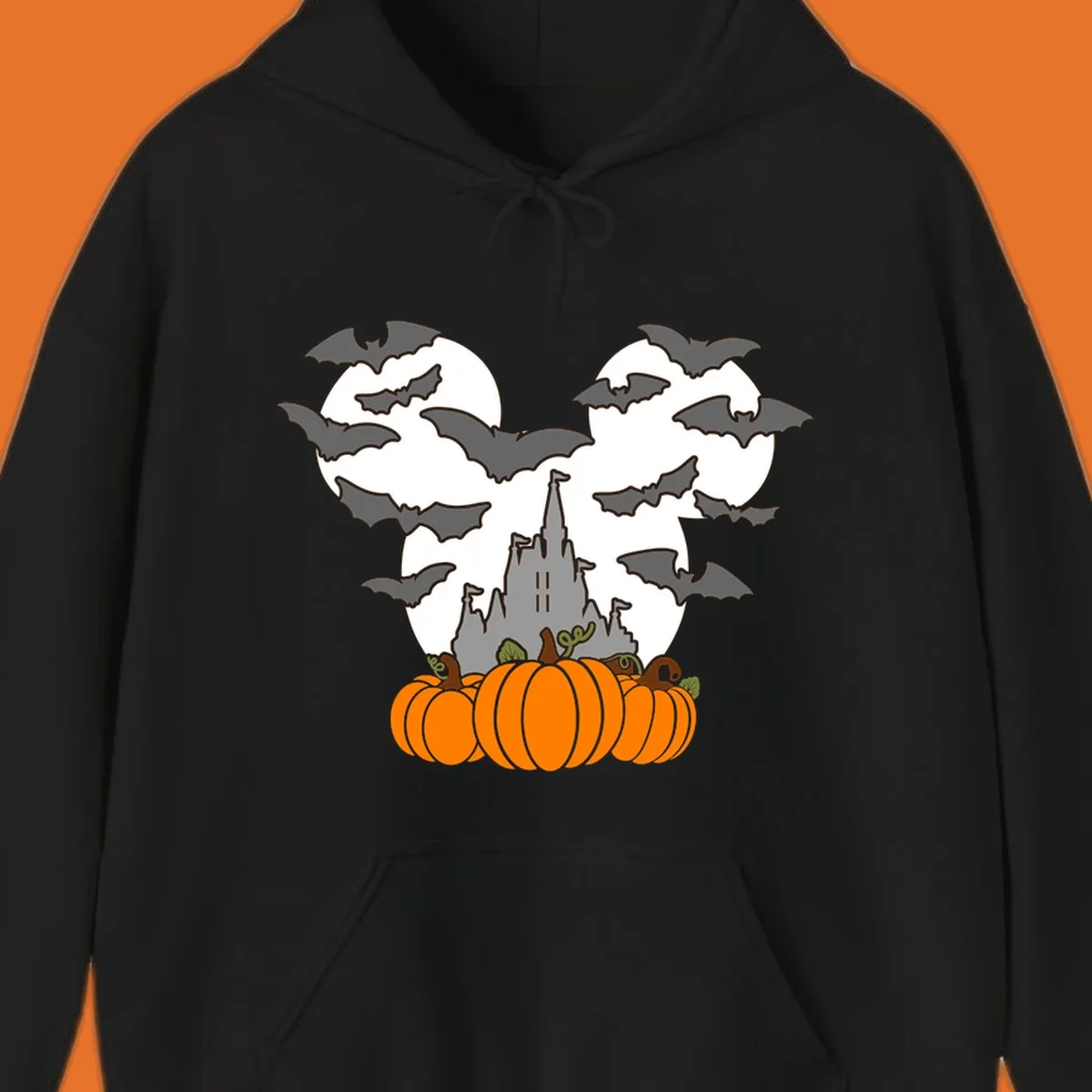 Halloween castle with bats and pumpkins against a Mickey Mouse ears moon graphic.