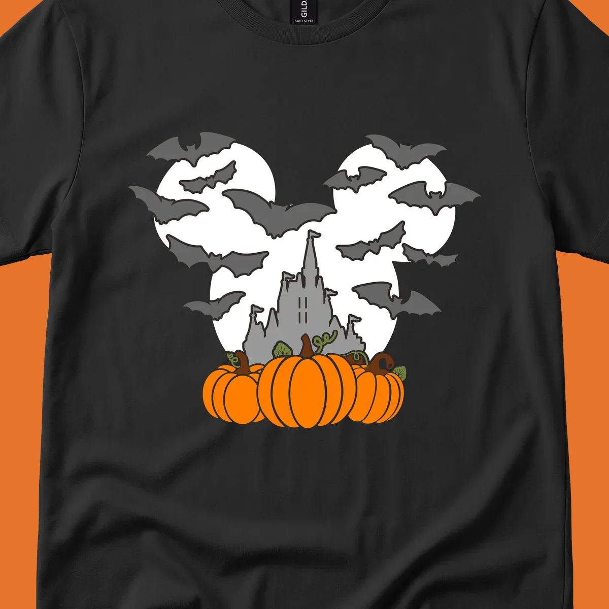 Halloween castle with bats and pumpkins against a Mickey Mouse ears moon graphic.