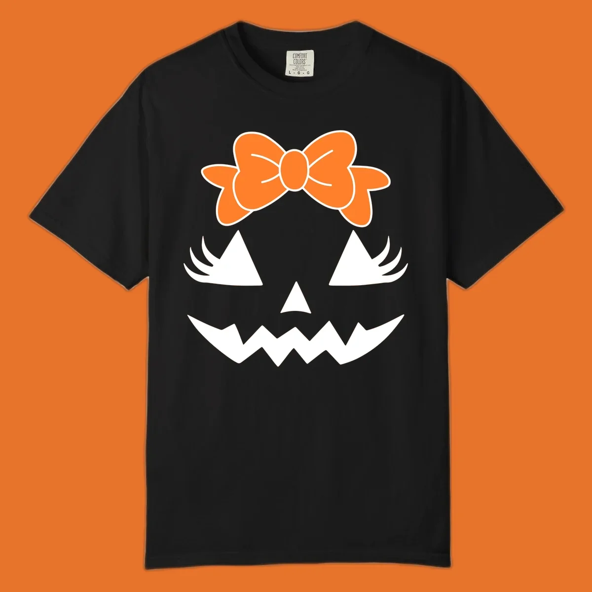 Cute pumpkin face graphic with orange bow, triangle eyes, nose, and jagged smile.