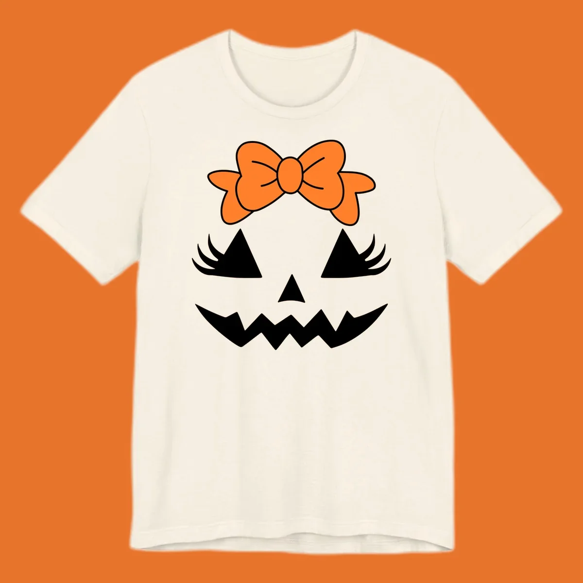 Cute pumpkin face graphic with orange bow, triangle eyes, nose, and jagged smile.