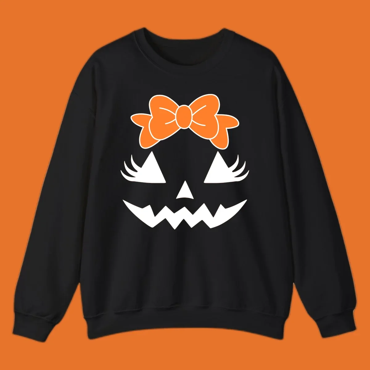 Cute pumpkin face graphic with orange bow, triangle eyes, nose, and jagged smile.