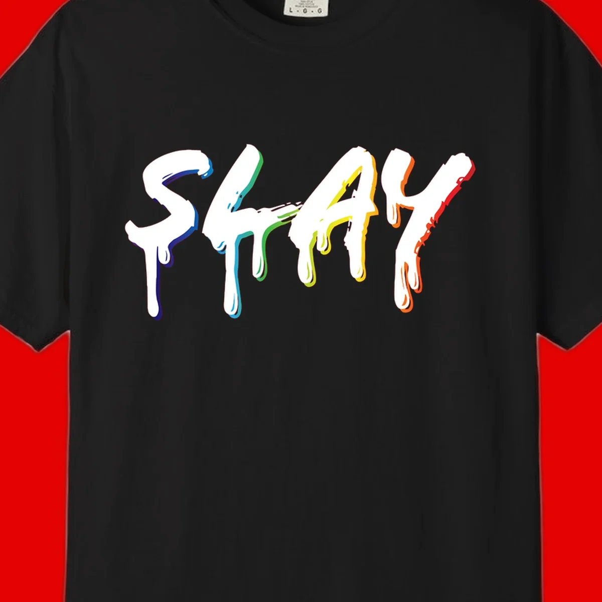 The word STAY in white letters with rainbow pride-colored paint drips flowing downward, featuring blue, teal, green, yellow, orange, and red colors on gray background