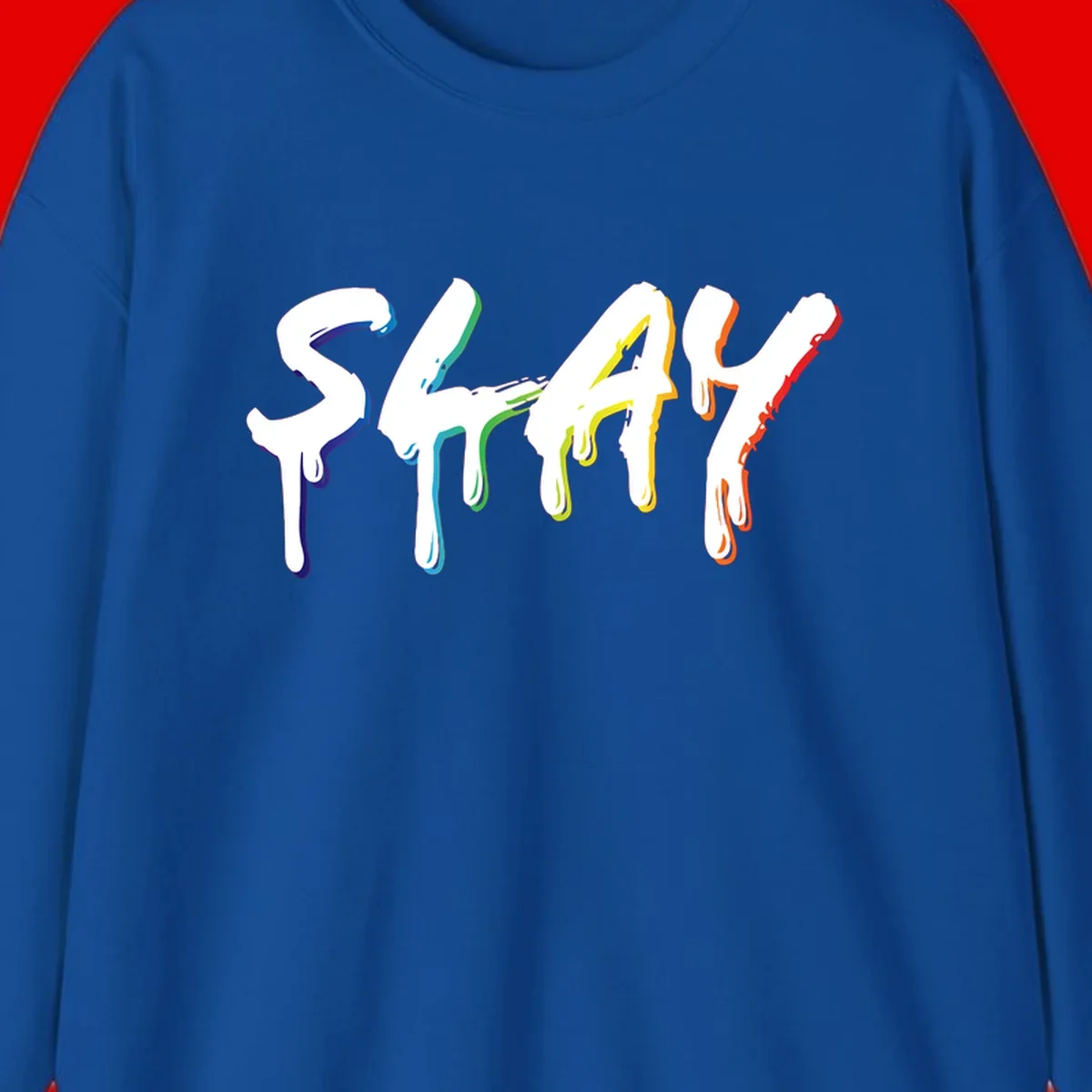 The word STAY in white letters with rainbow pride-colored paint drips flowing downward, featuring blue, teal, green, yellow, orange, and red colors on gray background
