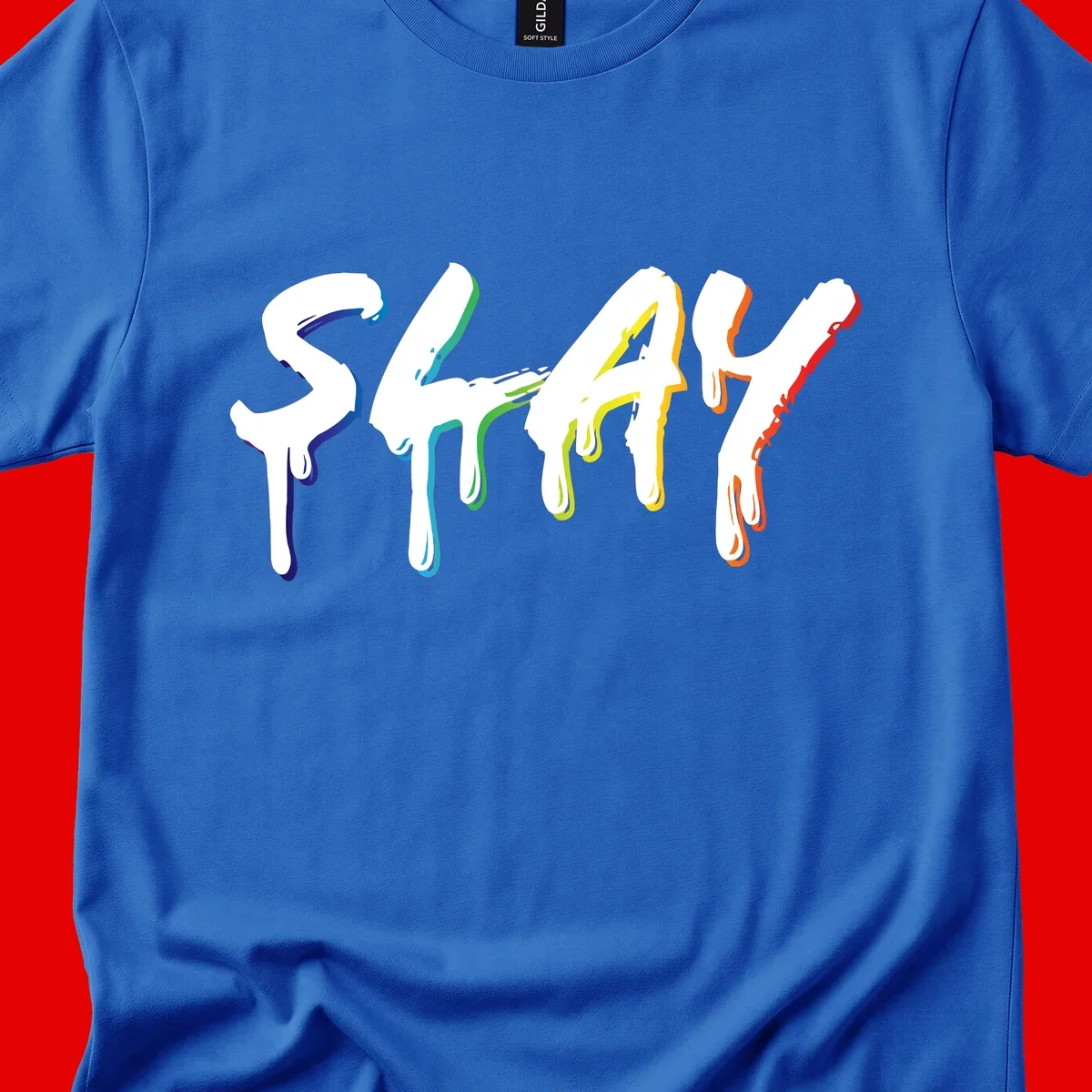 The word STAY in white letters with rainbow pride-colored paint drips flowing downward, featuring blue, teal, green, yellow, orange, and red colors on gray background