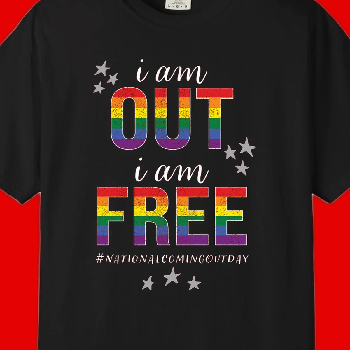 Rainbow-striped letters spelling 'i am OUT i am FREE' with decorative stars on gray background celebrating National Coming Out Day pride.