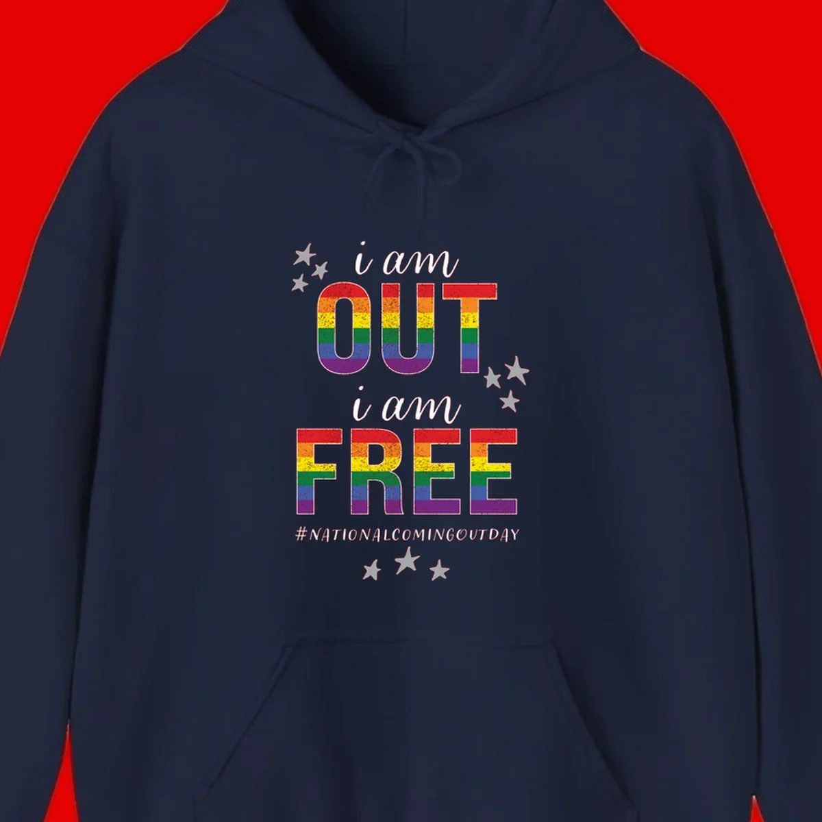 Rainbow-striped letters spelling 'i am OUT i am FREE' with decorative stars on gray background celebrating National Coming Out Day pride.