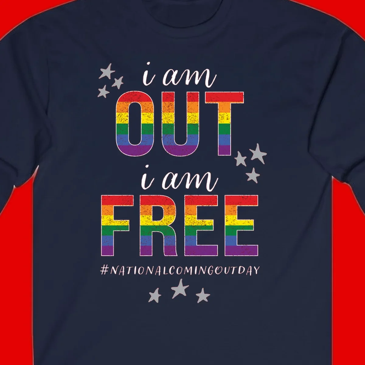 Rainbow-striped letters spelling 'i am OUT i am FREE' with decorative stars on gray background celebrating National Coming Out Day pride.