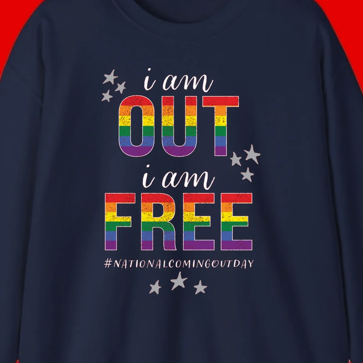 Rainbow-striped letters spelling 'i am OUT i am FREE' with decorative stars on gray background celebrating National Coming Out Day pride.