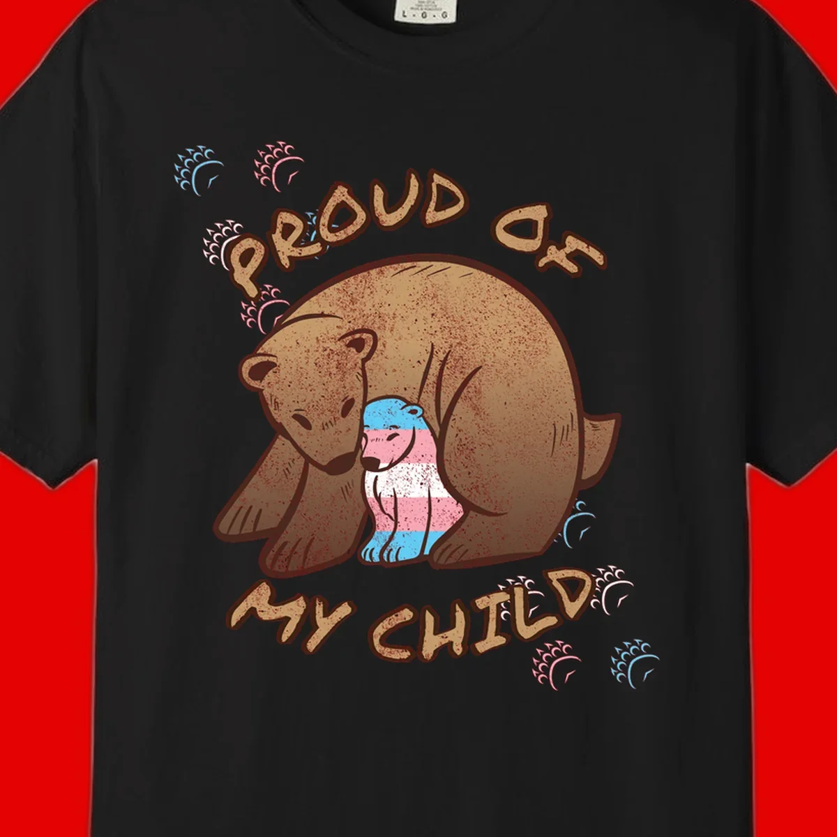 Brown bear holding a cub with blue, pink and white stripes, surrounded by 'Proud As My Chubby' text and decorative wave designs celebrating transgender pride