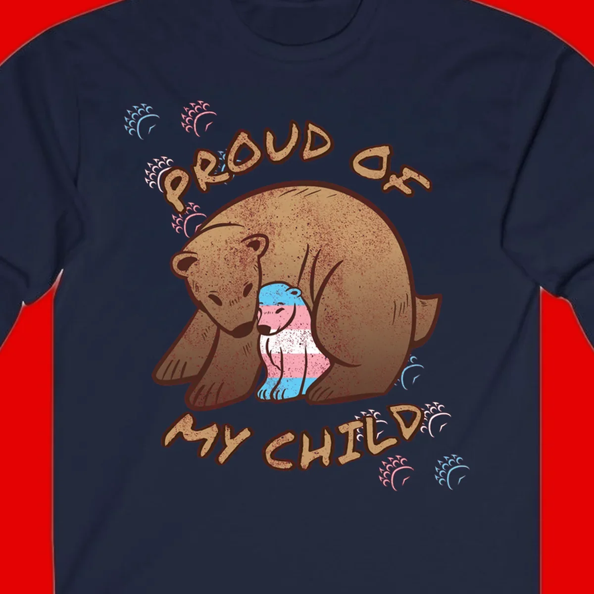 Brown bear holding a cub with blue, pink and white stripes, surrounded by 'Proud As My Chubby' text and decorative wave designs celebrating transgender pride