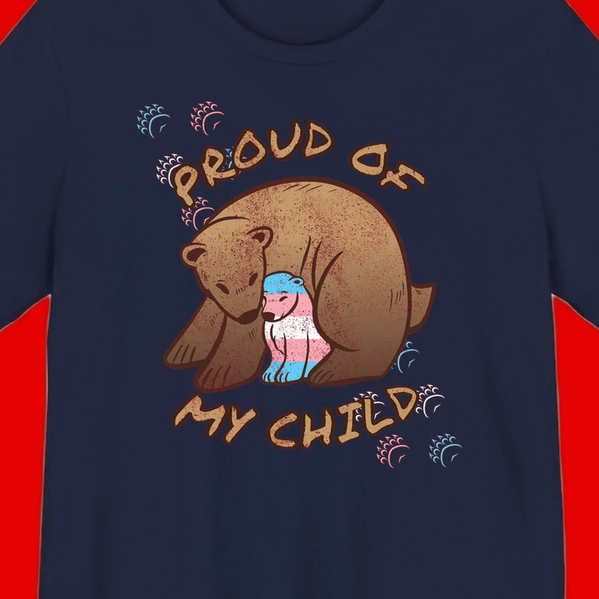 Brown bear holding a cub with blue, pink and white stripes, surrounded by 'Proud As My Chubby' text and decorative wave designs celebrating transgender pride