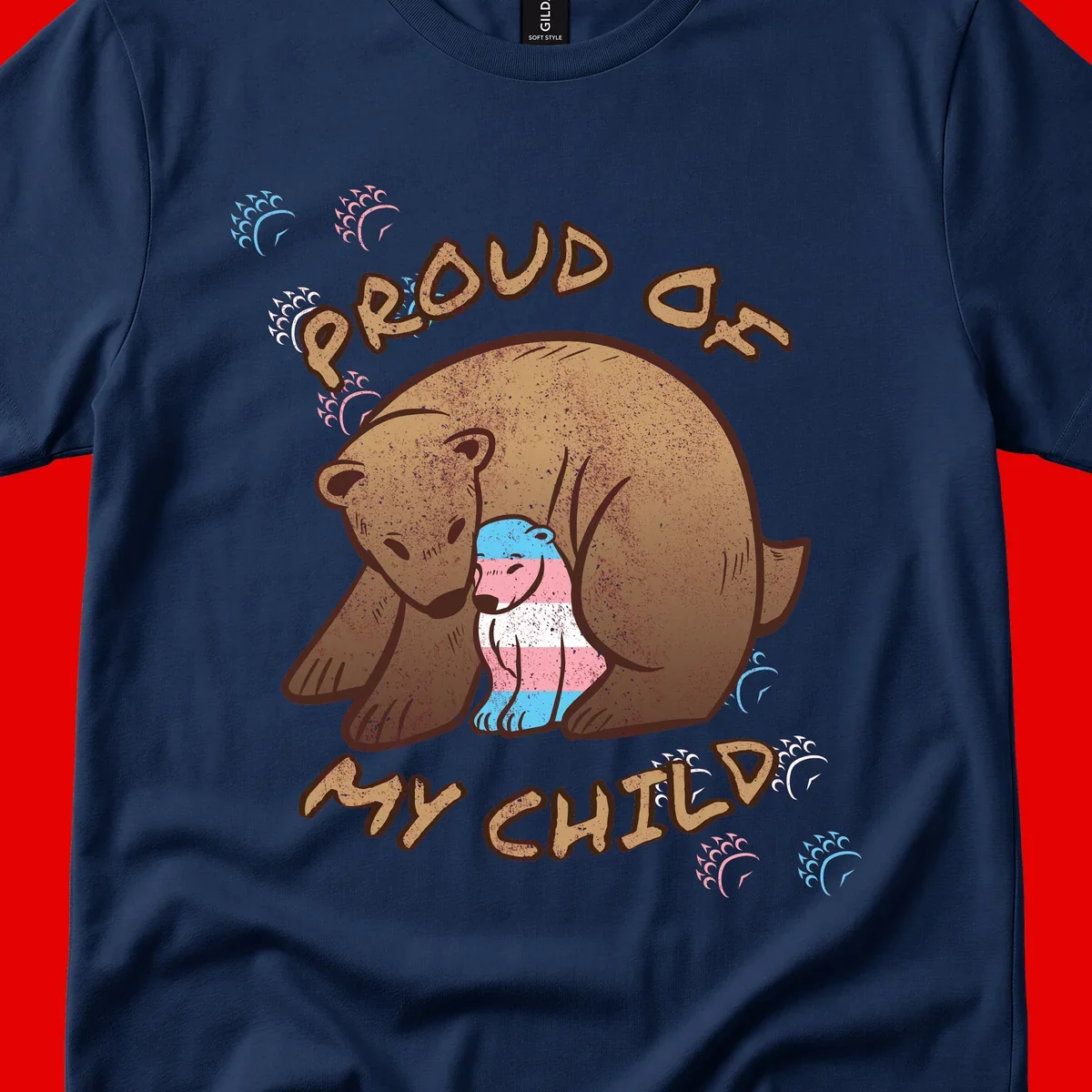 Brown bear holding a cub with blue, pink and white stripes, surrounded by 'Proud As My Chubby' text and decorative wave designs celebrating transgender pride