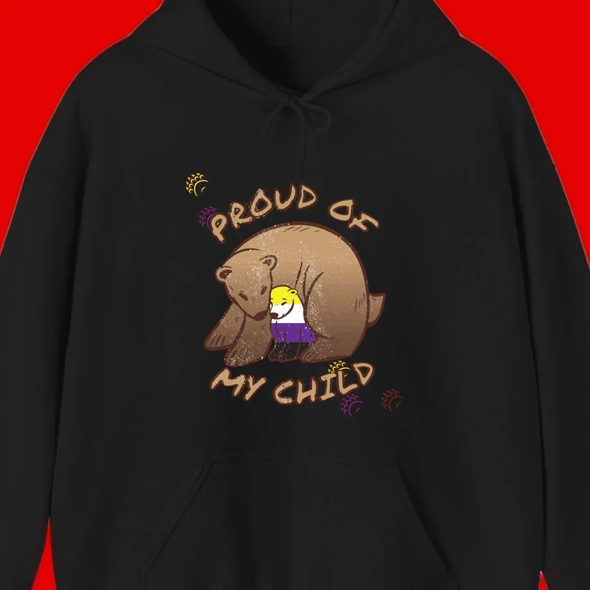 Illustration of a large brown bear's head in profile containing a small figure wearing pride flag colors, with text reading 'Proud As Child'