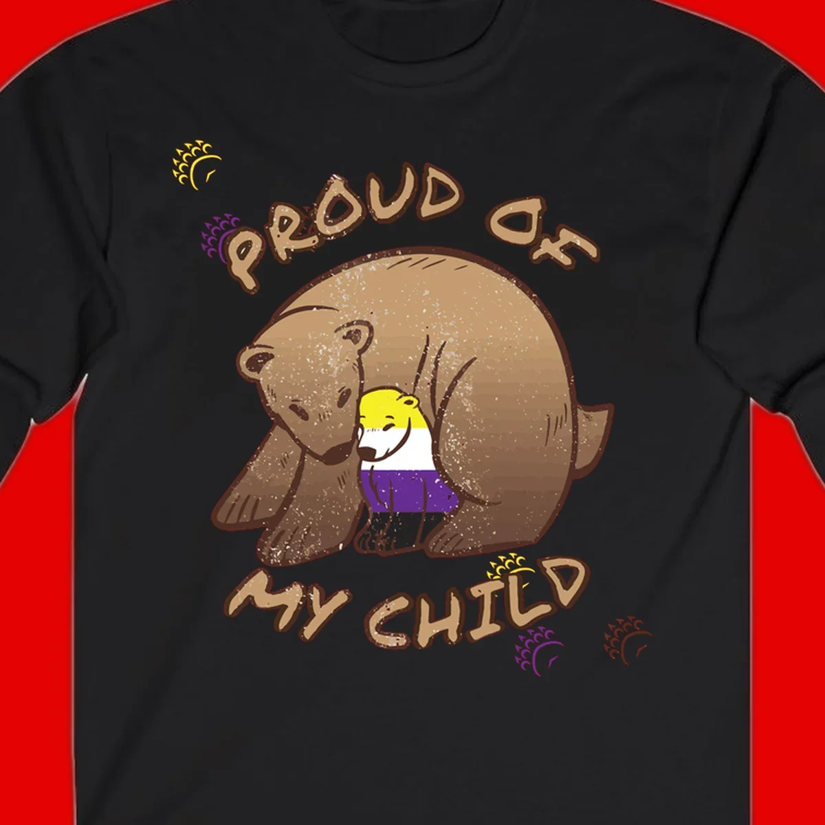 Illustration of a large brown bear's head in profile containing a small figure wearing pride flag colors, with text reading 'Proud As Child'