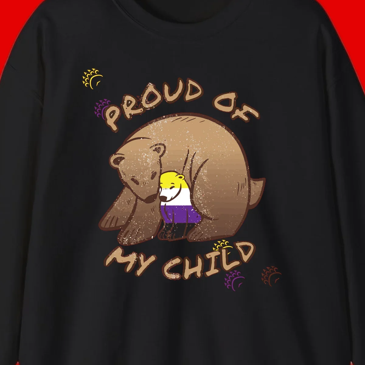 Illustration of a large brown bear's head in profile containing a small figure wearing pride flag colors, with text reading 'Proud As Child'