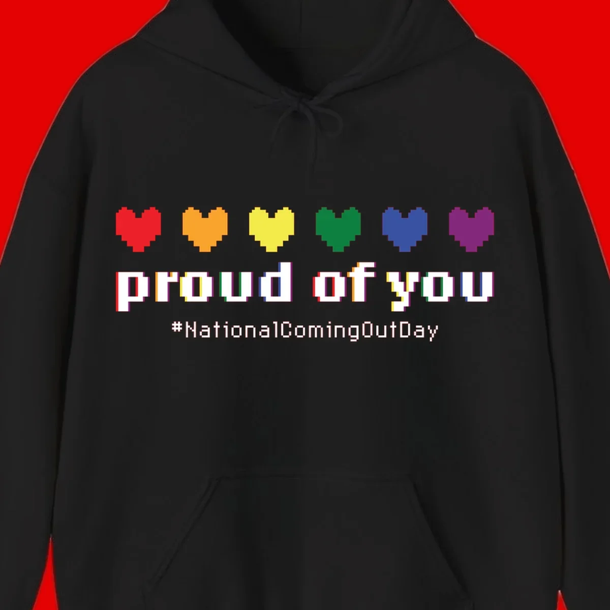 Pixel-art design with six rainbow hearts and text reading 'proud of you #NationalComingOutDay' celebrating coming out visibility