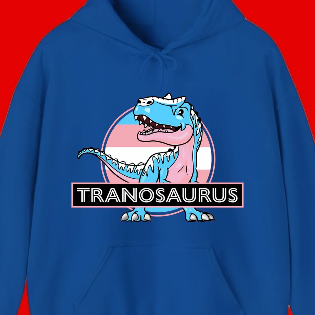 Blue cartoon T-Rex dinosaur with open mouth against pink and white pride flag circular background, labeled Tranosaurus