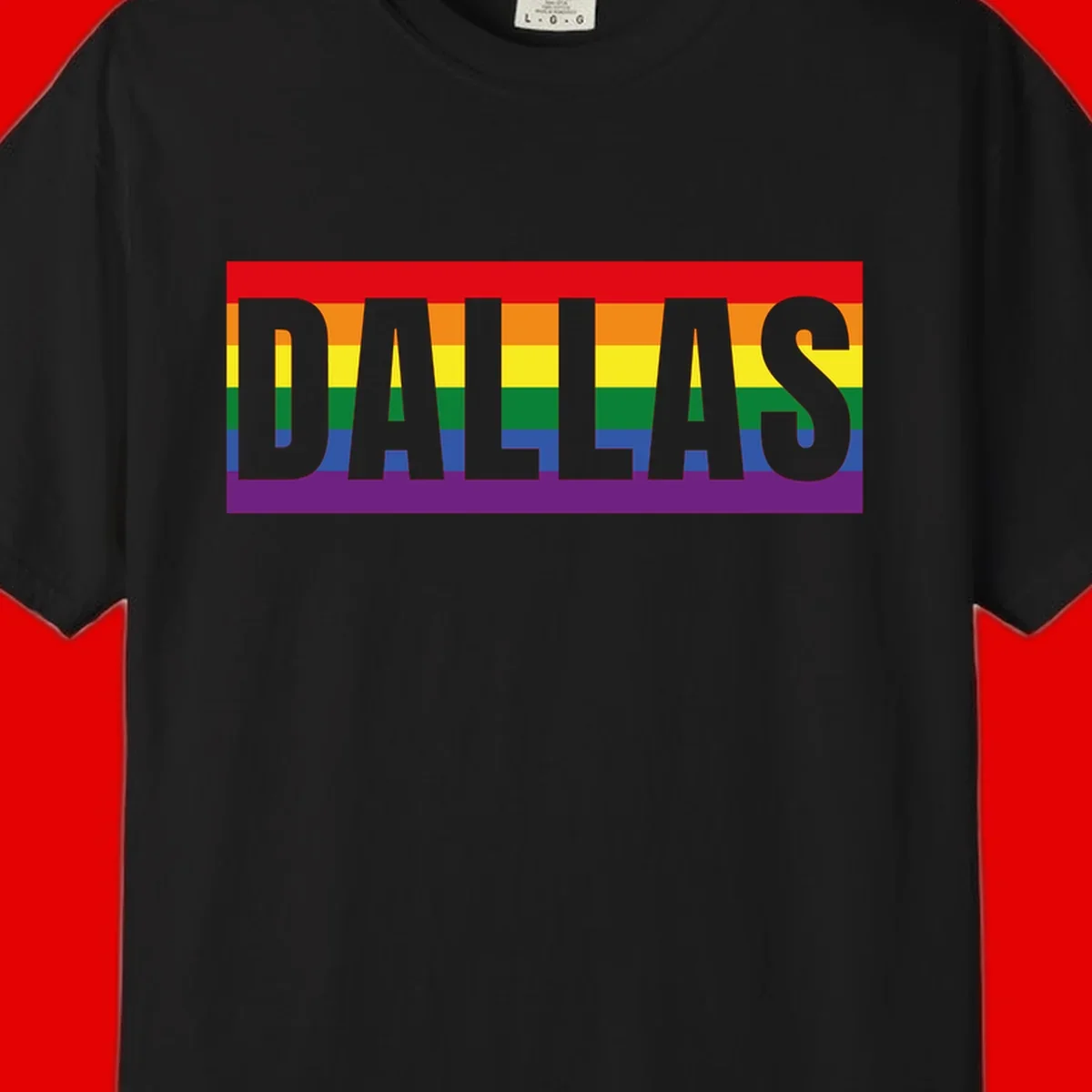 Gray DALLAS text overlaid on rainbow pride flag with red, orange, yellow, green, blue, and purple horizontal stripes