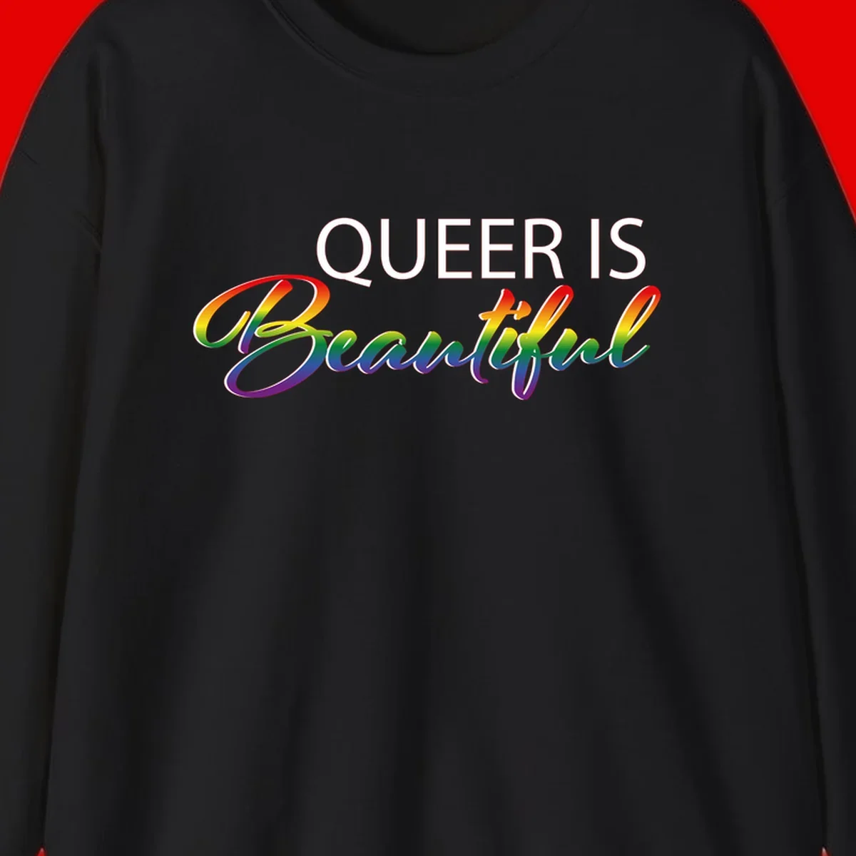 Rainbow gradient text reading 'Queer Is Beautiful' in pride flag colors on gray background
