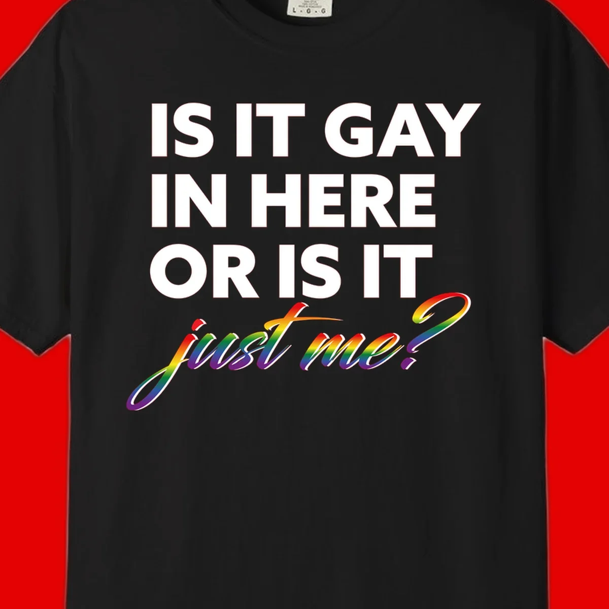 Bold white text reading "Is It Gay In Here Or Is It" with rainbow gradient lettering spelling "just me?" featuring pride flag colors on gray background