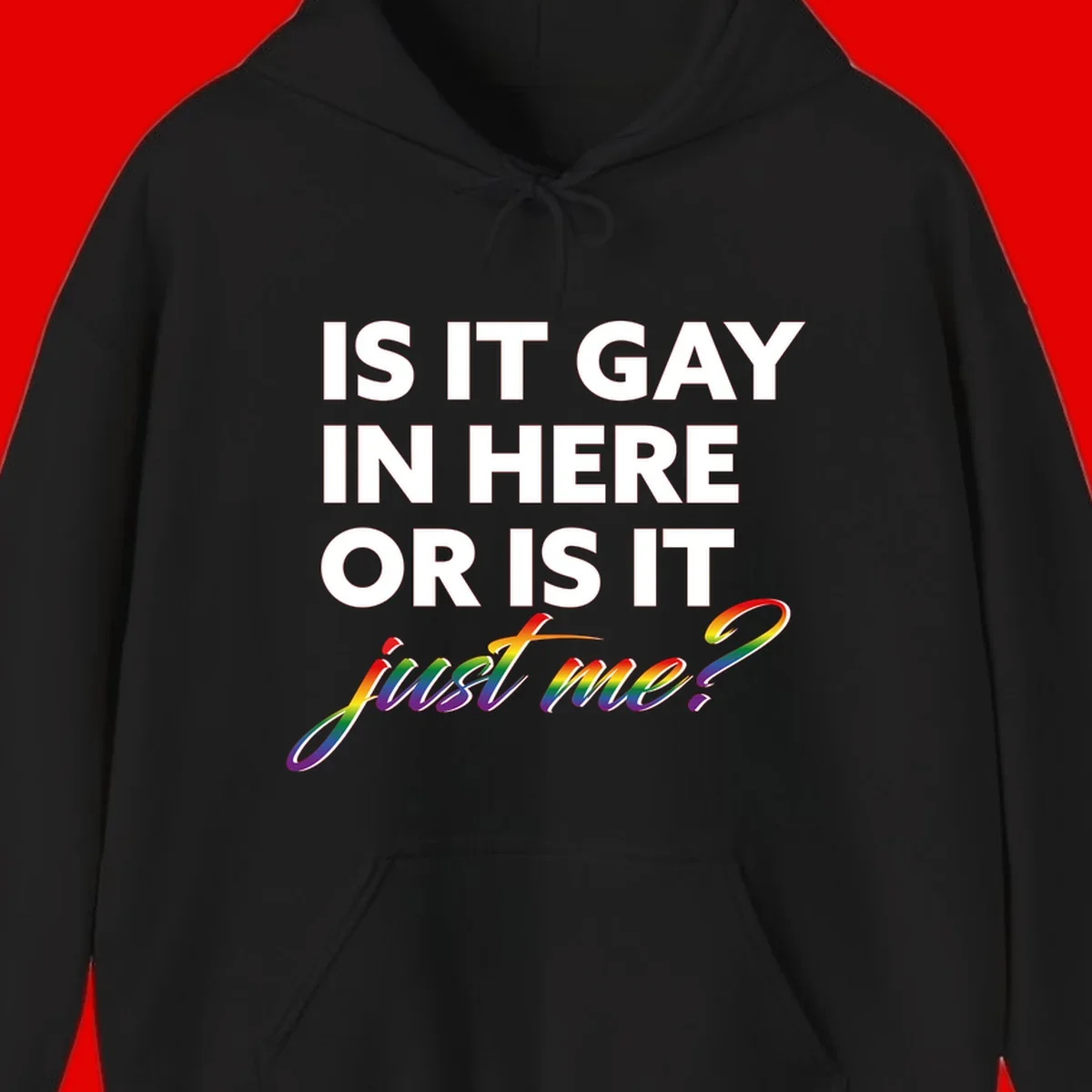 Bold white text reading "Is It Gay In Here Or Is It" with rainbow gradient lettering spelling "just me?" featuring pride flag colors on gray background