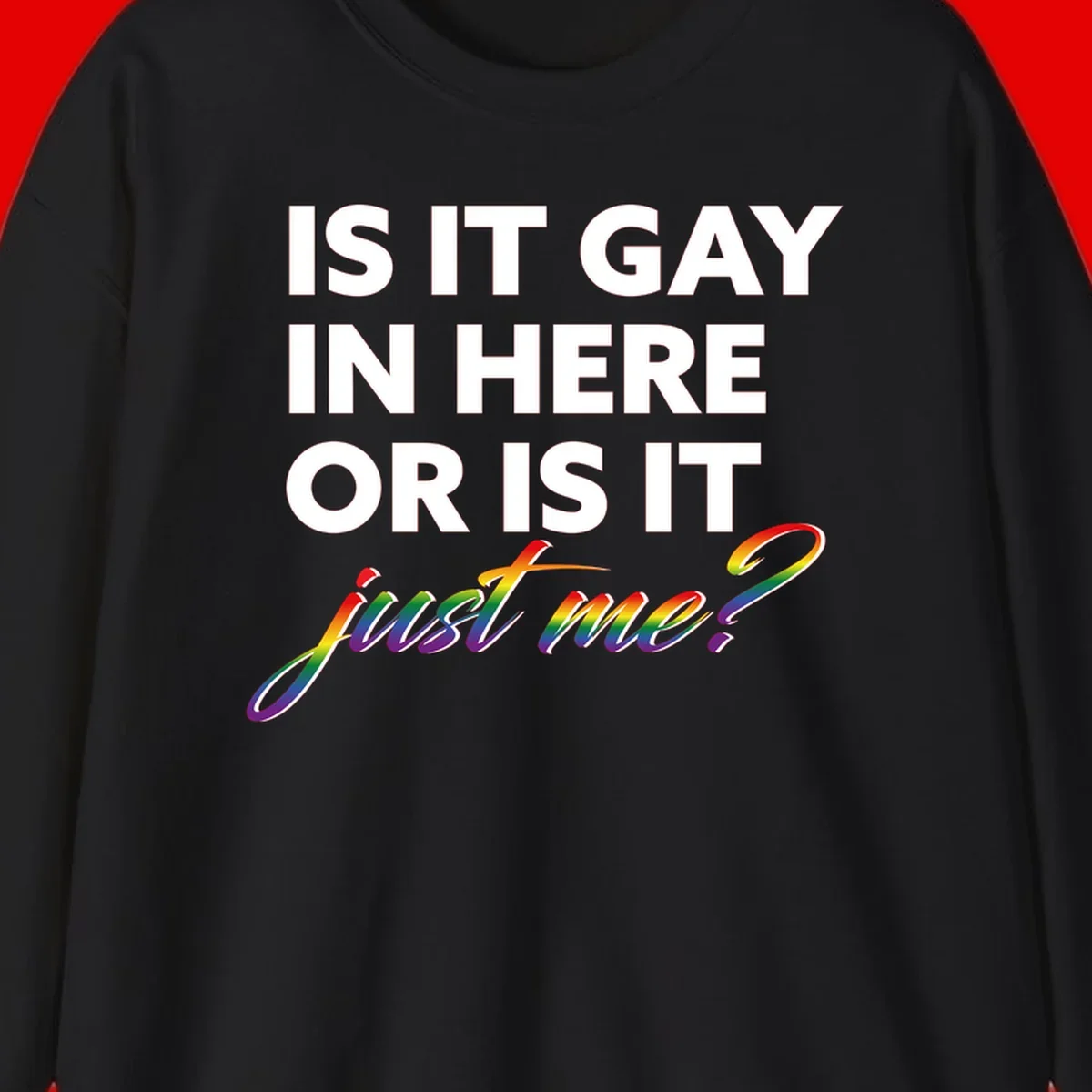 Bold white text reading "Is It Gay In Here Or Is It" with rainbow gradient lettering spelling "just me?" featuring pride flag colors on gray background