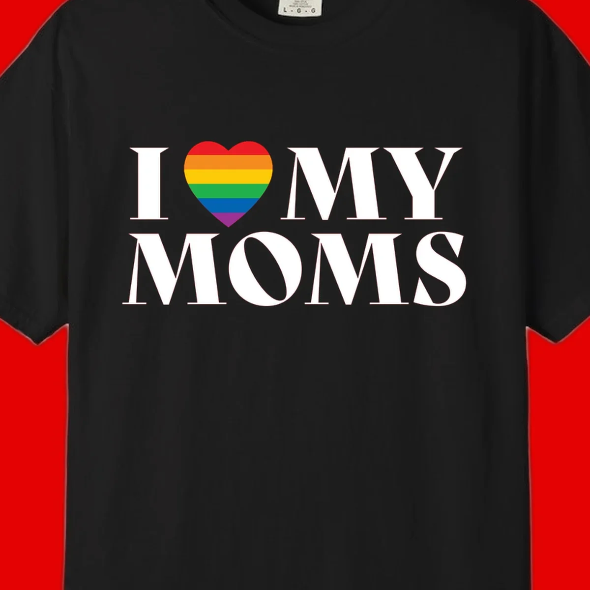 White text reading 'I love my moms' with a rainbow-striped heart symbol, celebrating LGBTQ+ family pride