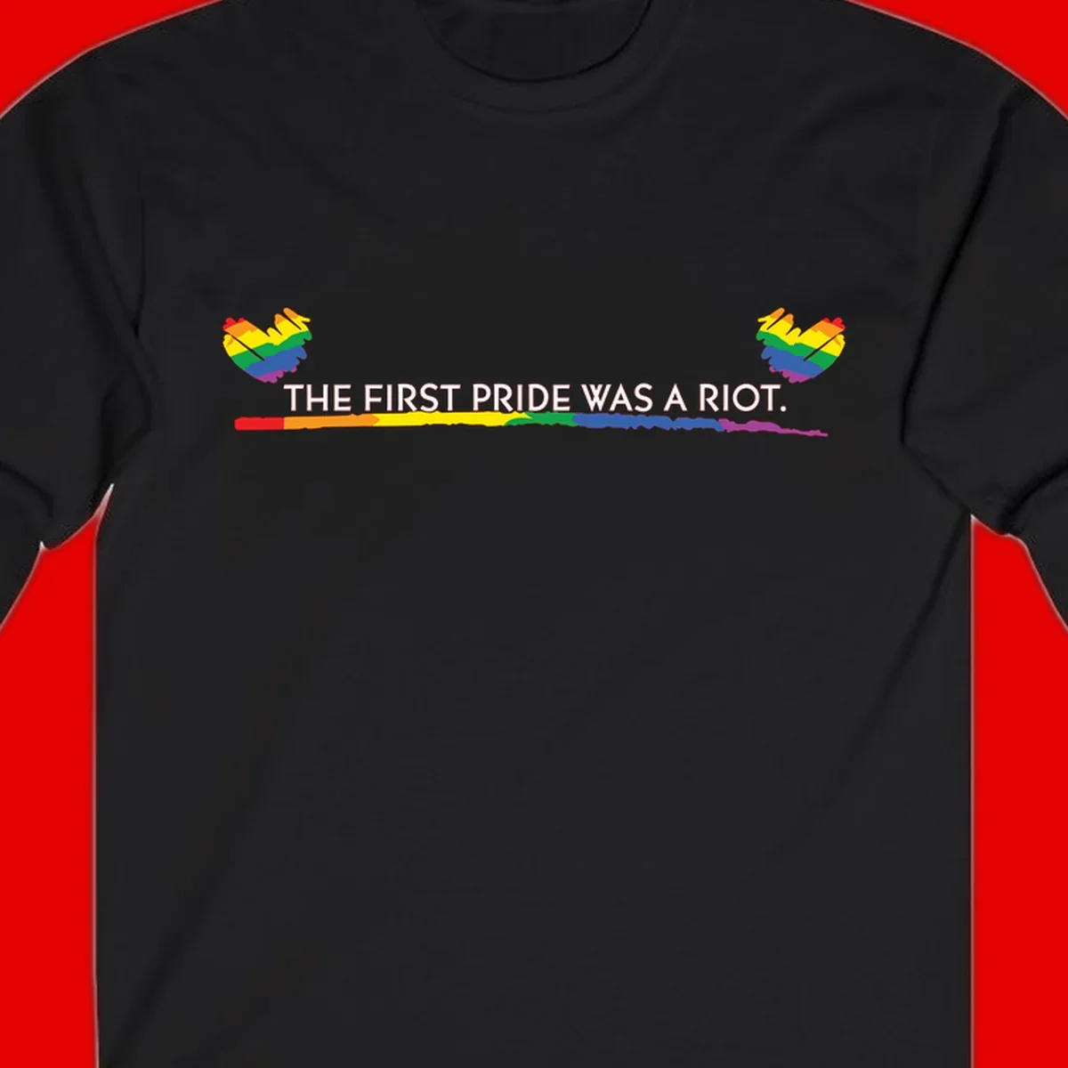 Gray background with white text reading 'THE FIRST PRIDE WAS A RIOT' surrounded by rainbow pride hearts and gradient stripe