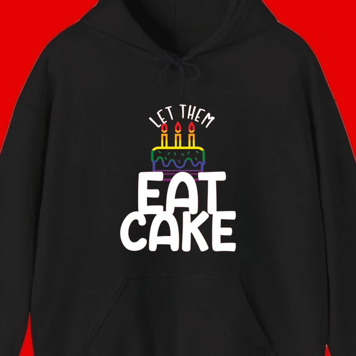 Rainbow-layered birthday cake with three candles above bold white text reading 'Let Them Eat Cake' - a Pride-themed design