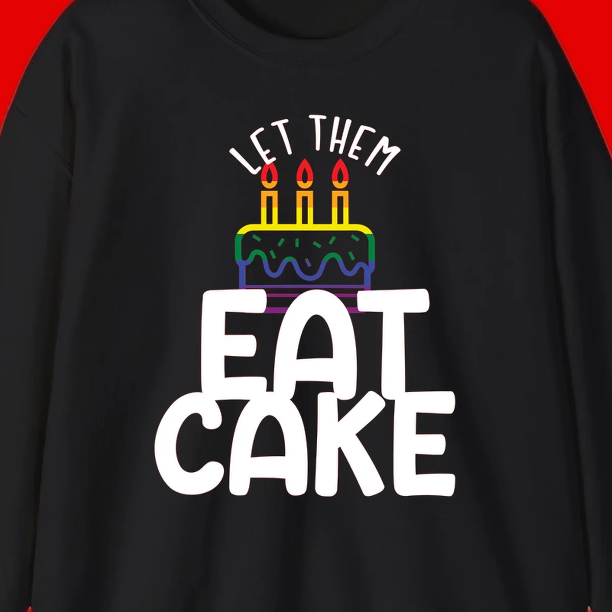 Rainbow-layered birthday cake with three candles above bold white text reading 'Let Them Eat Cake' - a Pride-themed design
